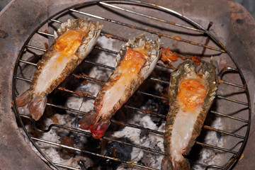 closeup river prawn and cut back with orange egg grilled by charcoal on grill.