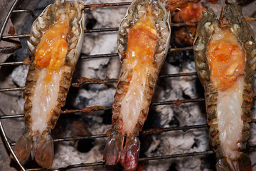closeup river prawn and cut back with orange egg grilled by charcoal on grill.