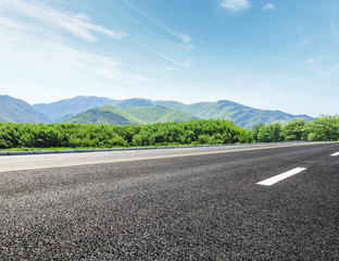 Fototapeta premium country road and mountains with forest in summer