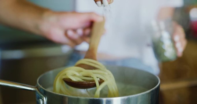 Close up of couple cooking together making pasta