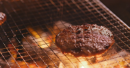 Grilled Beef Burger on barbecue metal net