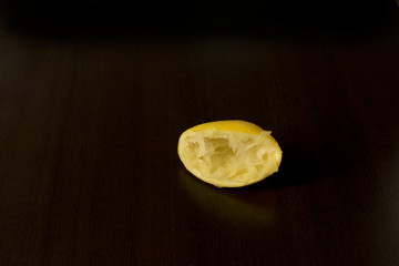Squeezed lemon skins on dark background - lemon peel - dark food photography, copy space