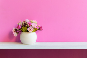 Pink wall with flower on shelf white wood, copy space for text.  Still life Concept