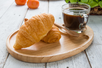 Tasty croissants on white wood background