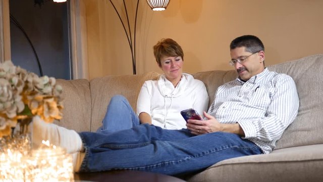Husband and Wife enjoy a funny text message through their smartphone