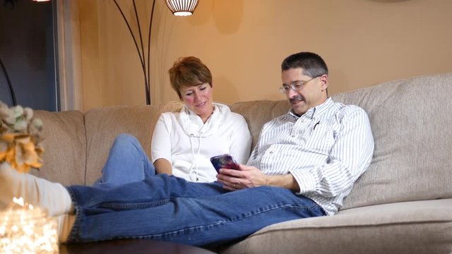 Husband and Wife enjoy a funny text message through their smartphone ALT