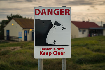 Sign: Danger unstable cliffs keep clear, seen in  Reculver, Kent, England, UK