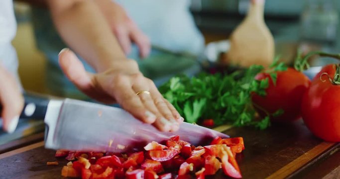 Close up of couple chopping fresh vegetables cooking in the kitchen