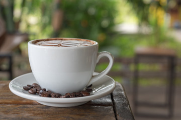 White coffee mug on patterned old wooden floor.