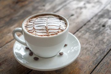 White coffee mug on patterned old wooden floor.