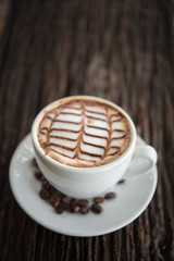 White coffee mug on patterned old wooden floor.