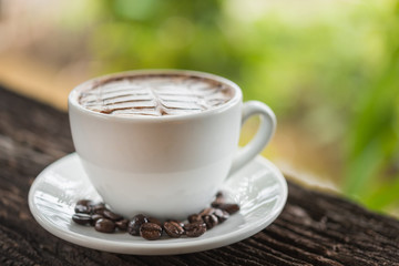 White coffee mug on patterned old wooden floor.