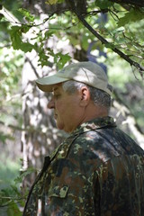 кавказский старик наслаждается тенью большого дуба в летнем лесу  