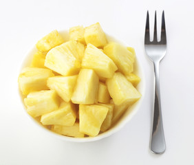 salad of choped pineapple in bowl with fork isolated on white background