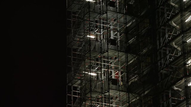 Camera pans across a high rise building scaffolding