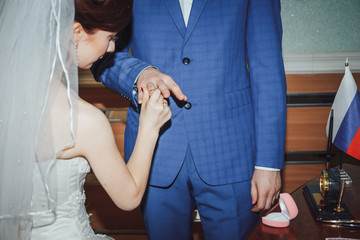 Obraz na płótnie Canvas Bride and groom exchange rings in the registry office