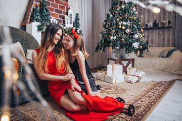 Two girls sisters have relax and fun in a room decorated for Christmas and the New year