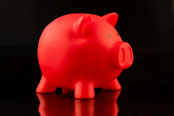 Rotes Sparschwein vor schwarzem Hintergrund