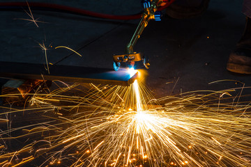 Factory worker cutting metal using acetylene torch, manual plasma cuting in a steel factory lot's...