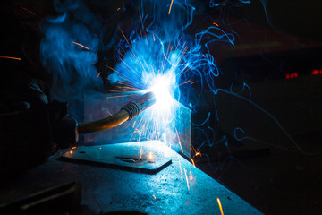 Worker welding construction by MIG welding, Worker welding the steel part by manual, welding splatter repairman, lifestyles, light weld - obrazy, fototapety, plakaty