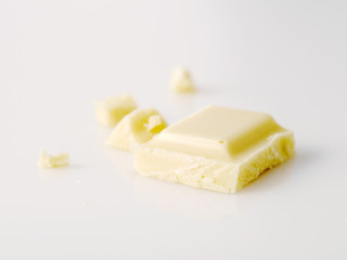 Macro photo of Chocolate bar. Broken pieces over white background