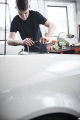 Young mechanic repair a car at a garage