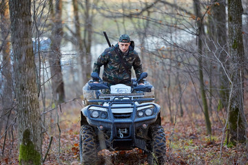 Hunter on ATV in the forest © Xalanx