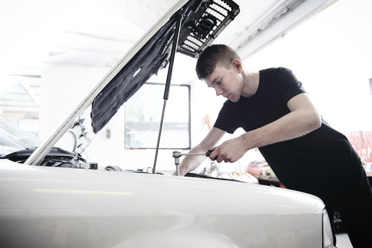 Young mechanic repair a car at a garage