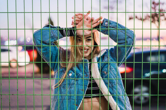 Seductive young model posing behind net