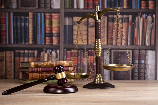 Judge's Gavel and scales of justice and law books in the background