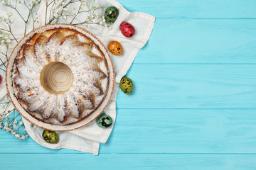 A plate with a delicious Easter cake and Easter eggs on a table
