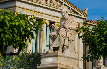 Statue of the great Greek philosopher Plato sitting on a marble chair, background of classical...