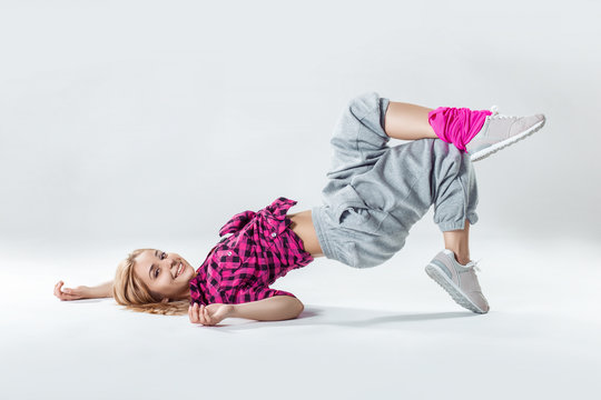 Young beautiful slim girl dancing on a white studio background