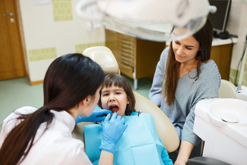 Obraz premium Dentist checking kid's teeth
