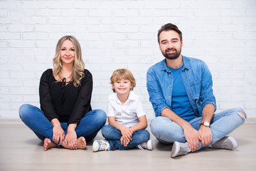 family with cute little school boy over white brick wall