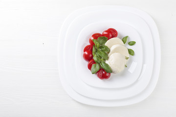 Mozzarella with tomato and green basil.