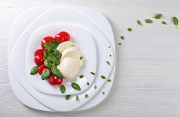 Mozzarella with tomato and green basil.