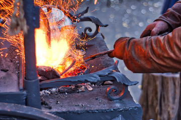 The smith is working on the horseshoe on a small forge furnace. Horseshoe forging at the Russian fair in Moscow.