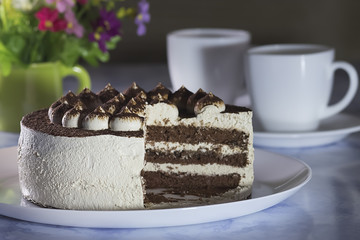 Chocolate Cake with Cream and Two  White Cups of Coffee .