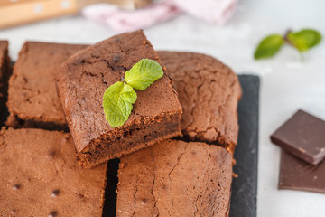 Pieces of dark chocolate brownie on slate board.