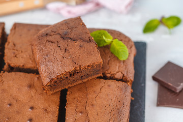 Pieces of dark chocolate brownie on slate board.