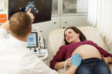 Young pregnant woman getting ultrasound diagnostics