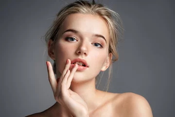 Fotobehang Image with beautiful blonde girl touching her lips on grey background. Beauty & Skin care concept © Romario Ien
