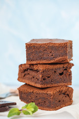 Homemade dark chocolate brownie, a stack of slices with mint, space for text