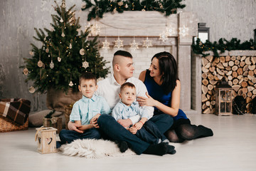  family sitting near a Christmas tree
