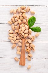 Pistachios nuts on a white wooden background. Healthy snacks. Top view. Free space for text.