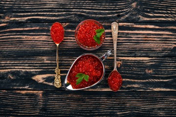 Red salmon caviar. On a wooden background. Top view. Free space for text.