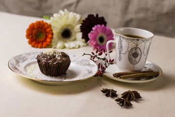 Chocolate fondant on a white plate with coffee and flowers