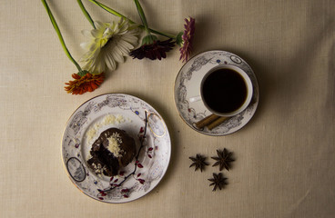 Fototapeta na wymiar Chocolate fondant on a white plate with coffee and flowers