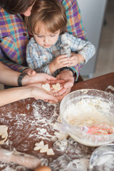 Obraz na płótnie Canvas family preparing homemade cookies in shape of heart